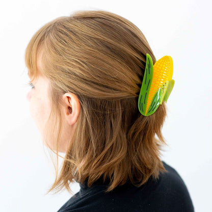 Blonde model with corn hair claw in hair against a white background.