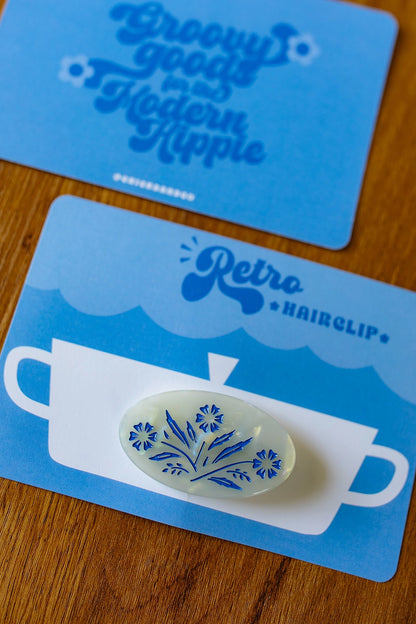 Hair clip on a blue display packaging on a wooden background.