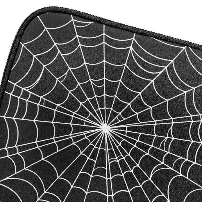 Close up of the white spiderweb design on the front of the laptop sleeve against a white background