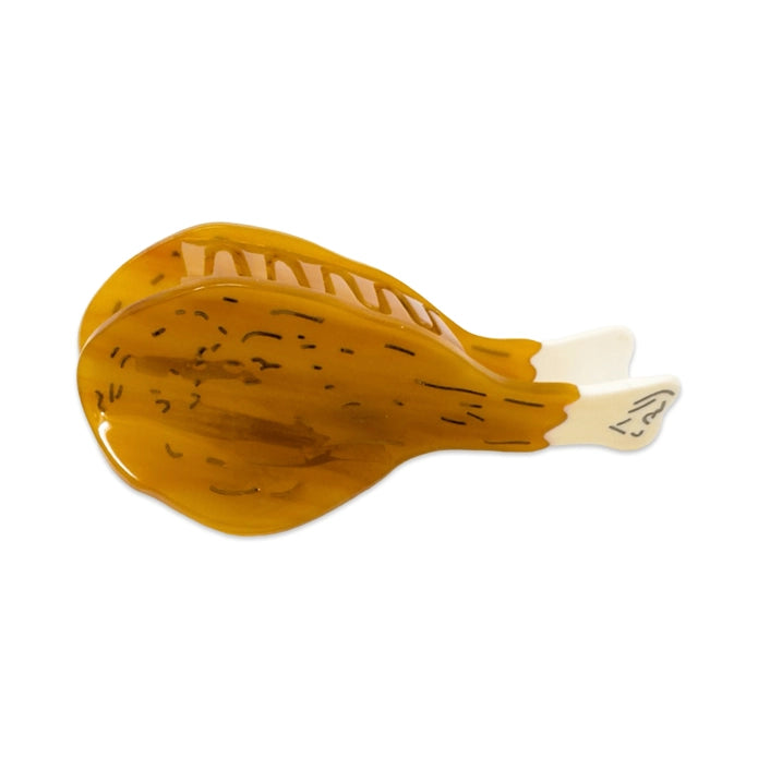 Drumstick hair claw at an angle showing teeth of hair claw against a white background.