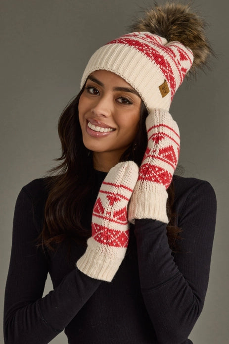 Woman wearing a red and white patterned knit hat and mittens against a gray background.