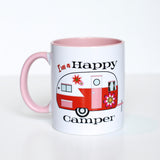 This photo shows the mug with the handle to the left. Has the phrase "I'm a Happy Camper" surrounding the red, white, and with 60s inspired florals camper. Camper has a white top and red bottom. Handle of the mug is a light pink