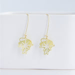 This photo showcases an up close look at the Starburst earrings in gold. They are hanging from a white item