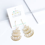 This photo shows the earrings laying down against a white background, and on the earring card with A Tea Leaf Jewelry's logo on it