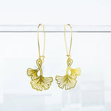 This photo shows a close up of the earrings. Earrings are a gold color with long hooks for the earrings. Ginko Leaves are also in gold