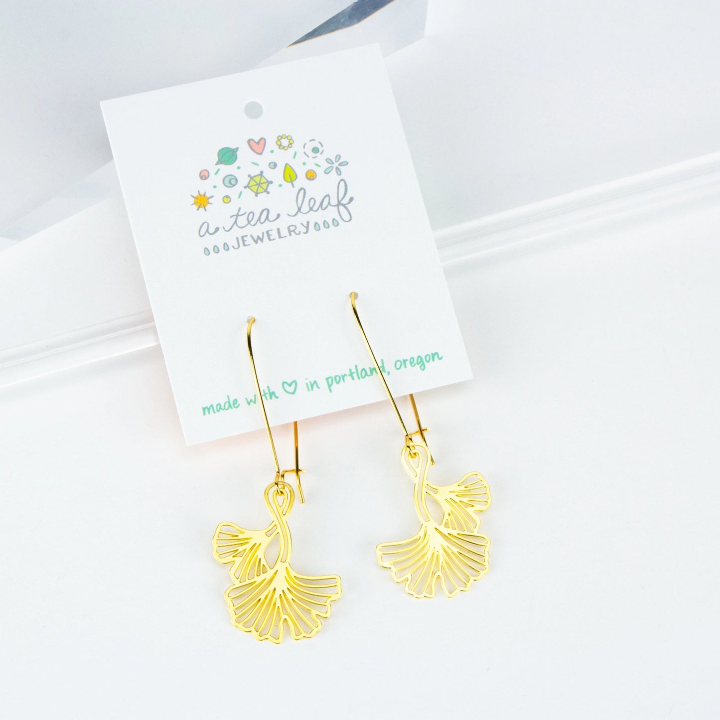 This photo shows the earrings on an earring card. Earrings are gold in color with long earring hooks