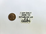 The phrase "I am only here to establish an alibi" in black lettering on a white background. Sticker is contour cut around words. Shown next to a quarter to showcase size