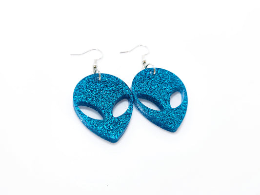 Teal glitter alien head shaped earrings. Earring style are hook earrings