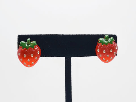Red strawberry stud earrings with white seeds, and a green top. Earrings are shown on a black earring stand