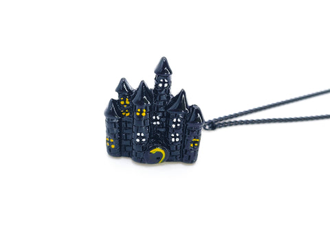 Spooky black castle with yellow and white windows attached to 2 black chains
