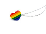 Heart with rainbow lines. Rainbow colors include: red, orange, yellow, green, dark blue, light blue. Heart is attached to 2 silver chains