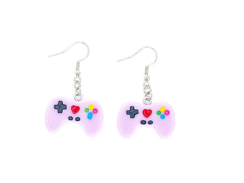 Light purple Video game controller earrings that are styled like xbox controllers as earrings. Has a red painted heart in the middled of the controller