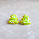 Photo shows the earrings up close. Earrings are pine tree shaped with light green frosting background and a white frosting line in a zig zag with yellow and red dots to look like ornaments