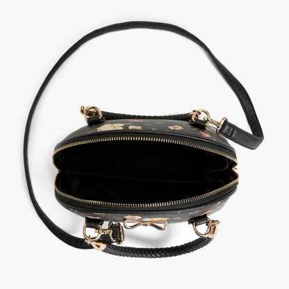 This photo shows an aerial view of the inside of the purse, which is a plain black fabric, and the long strap the purse comes with layng down around the purse