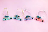 All 4 cars in a line against a pink background