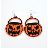 This photo shows the earrings against a white background. Earrings areorange pumpkin buckets with black details. Pumpkin is carved as an scary jackolantern