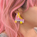 This photo shows an upclose look at the earrings being worn on a white model with pink hair. Earrings are a stud earring about 2 inches off of the ear lobs