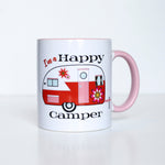 This photo shows the mug with the handle to the right. Has the phrase "I'm a Happy Camper" surrounding the red, white, and with 60s inspired florals camper. Camper has a white top and red bottom. Handle of the mug is a light pink
