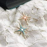 This photo shows both colors the pin is available in, which is blue and orange. Both pins are set against a white lace doily background