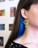 This photo shows the earring on a white model with brown hair, and a blue streak in the hair. Earring hangs about 3 inches from the ear
