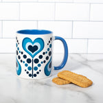 Mug against a white tile background with 2 cookies to the side