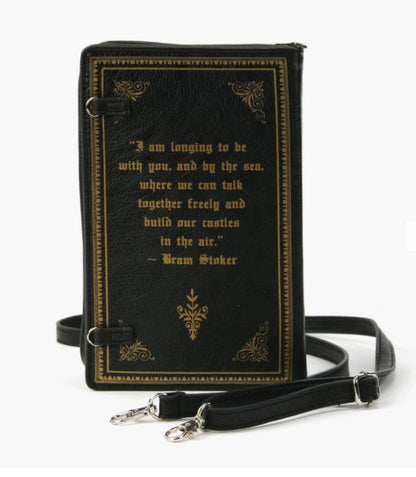 This photo shows the backside of the bag in black matte vinyl with gold details along the edge. In gold letters it reads "I am longing to be with you, and by the sea. Where we can talk together freely and build our castles in the air." -Bram Stoker