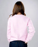 Light pink sweater with dark pink lettering saying "Not your babe" lettering is an outline lettering.  Photo shows the plain backside of the sweater and it being worn by a brunette white female presenting person