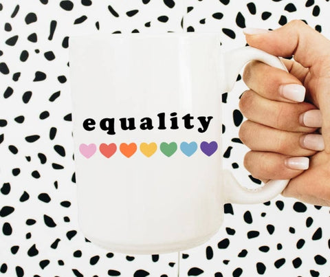 Photo shows mug up close. Mug is white with the word "Equality" in black font and rainbow hearts underneath