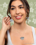 Model wearing silver earrings and matching necklace