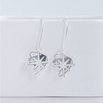 This photo showcases the Starburst earrings against a white background. Earrings are hanging from a white item