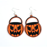 This photo shows the earrings against a white background. Earrings areorange pumpkin buckets with black details. Pumpkin is carved as an scary jackolantern