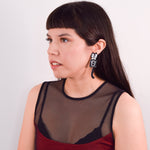 Model wearing earrings against a white background