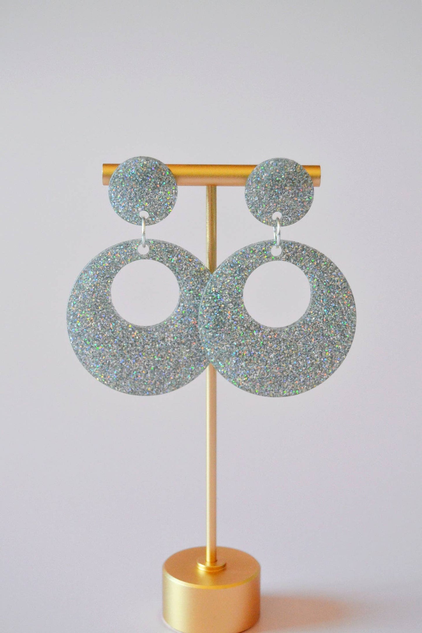 Earrings hanging from display against a light background