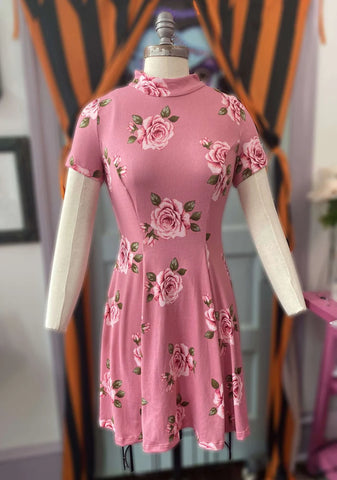 This photo shows the dress on a white mannequin. Dress is a dusty rose pink with light pink roses